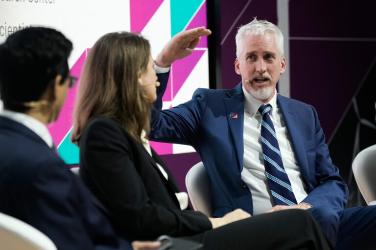 Dr. Holmes speaks to other presenters on a panel at CERAWeek.