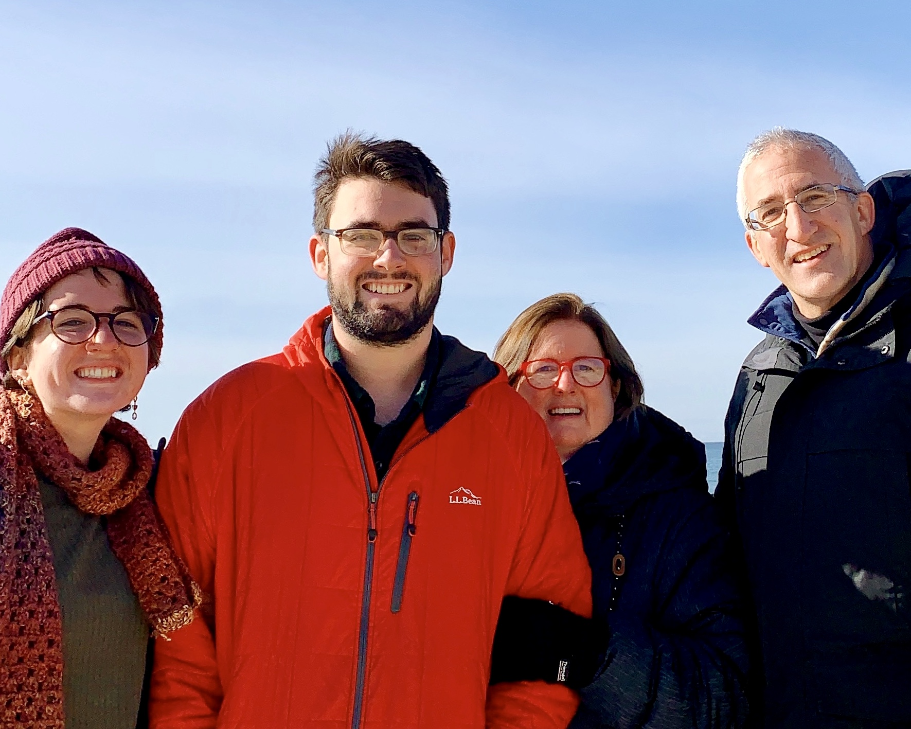 Family of four - mother, son, daughter, father - in winter outdoor gear.