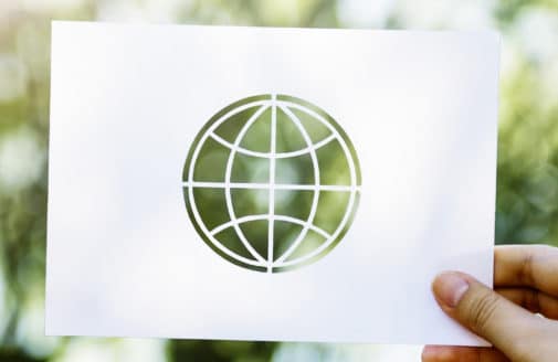 paper with globe outline cutout with trees behind