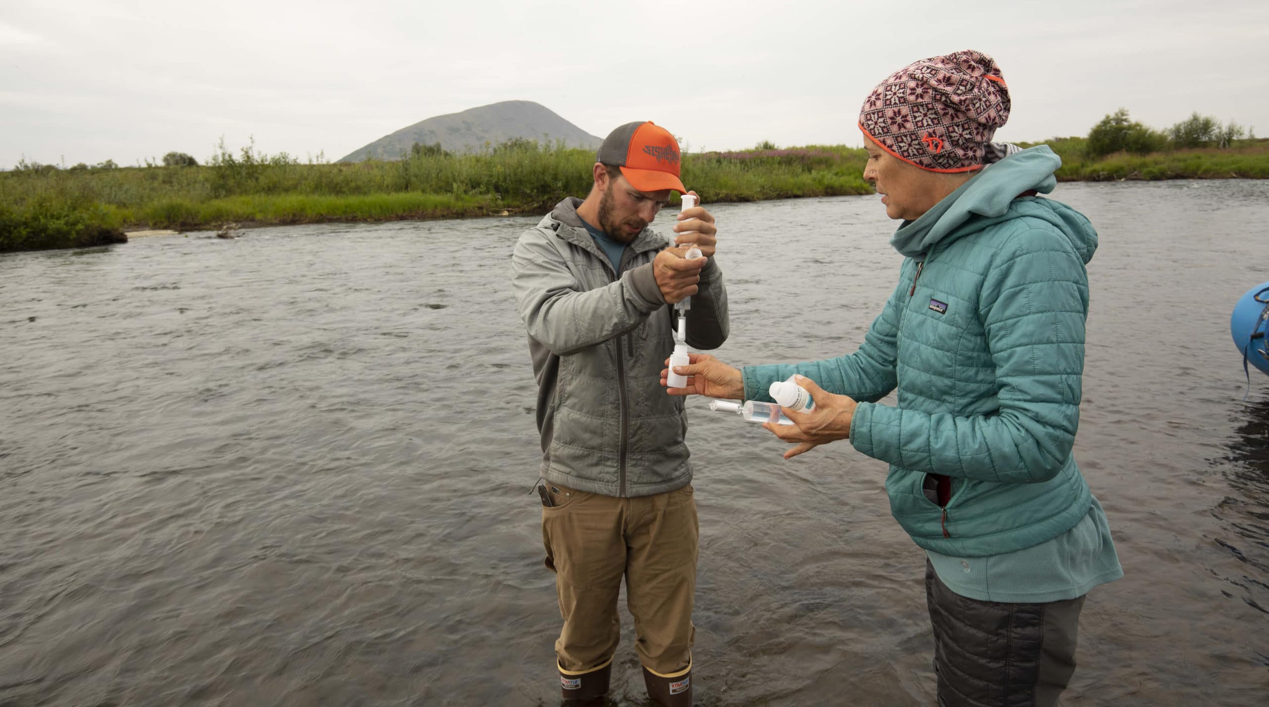 two scientists take river water samples