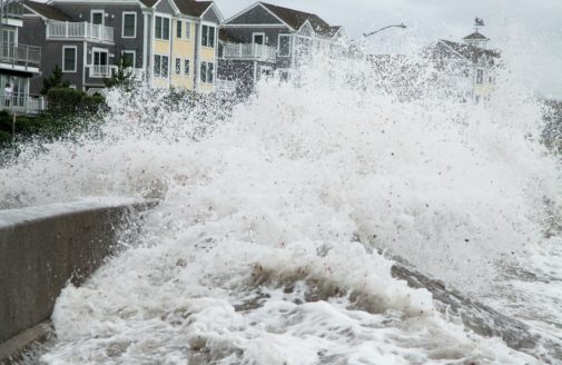 storm waves crashing over a retaining wall