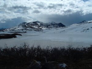 A snowy Arctic mountain with grey clouds overhead