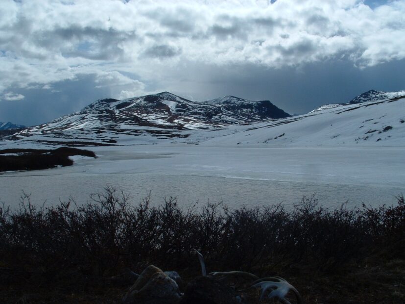 A snowy Arctic mountain with grey clouds overhead