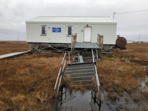 A building entrance walkway lies sinking in thawing permafrost