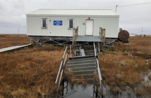 A building entrance walkway lies sinking in thawing permafrost