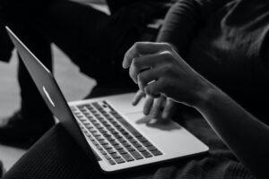 black and white photo of hands typing on a computer