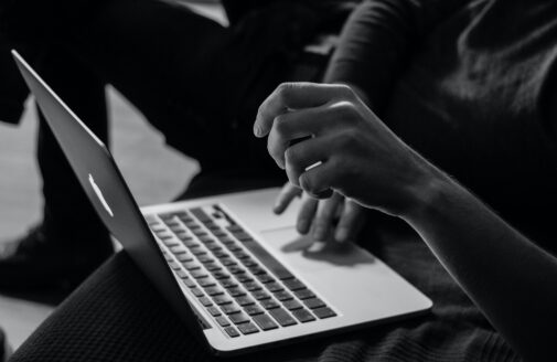 black and white photo of hands typing on a computer