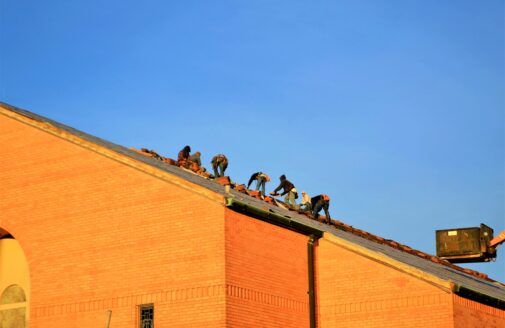 Men work on a roof in the hot sun