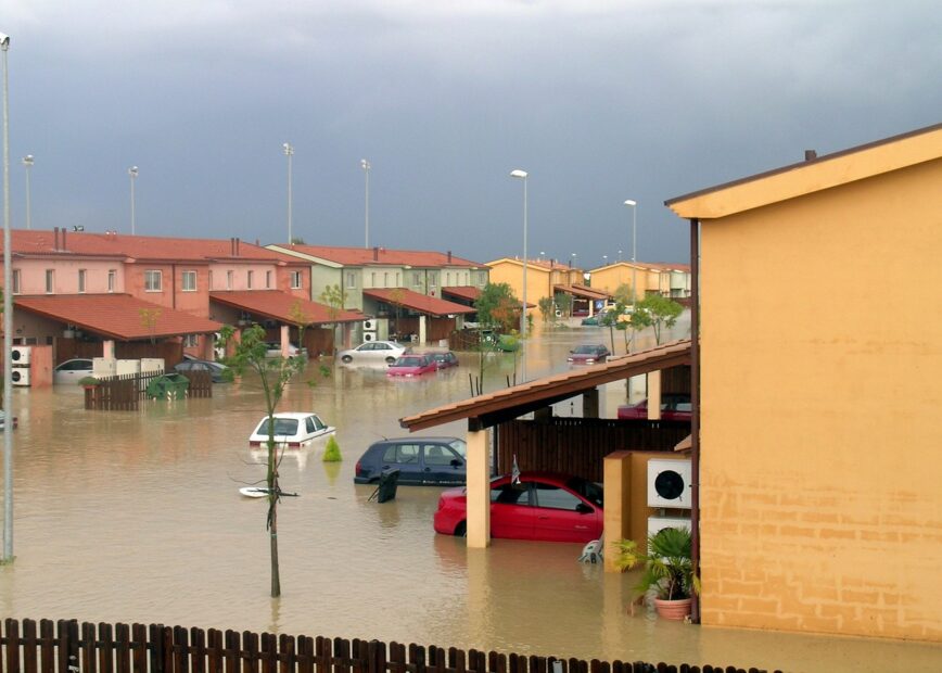 Floodwaters surround cars and houses