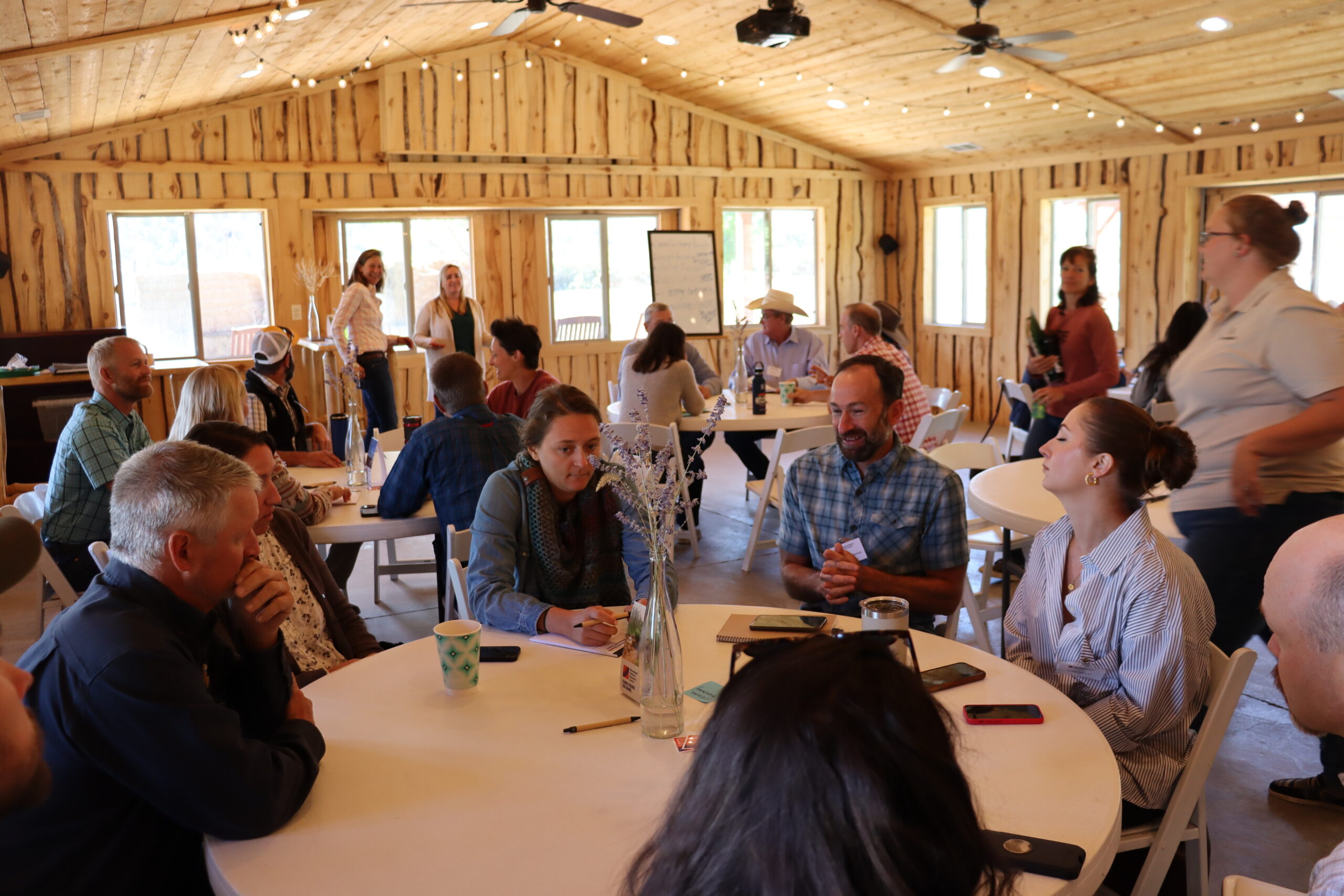 group sitting at a table in a barn discussing soil carbon