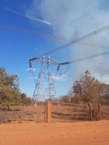 smoke rises from dry vegetation near an electric power line