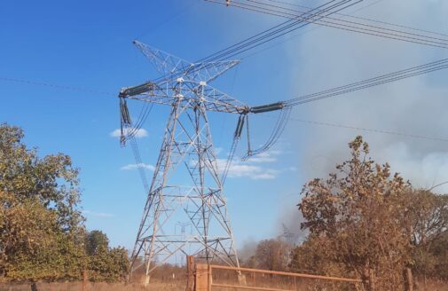 smoke rises from dry vegetation near an electric power line