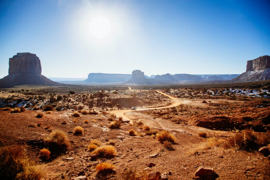 A truck drives on a road on a sunny day in Arizona's Monument Valley