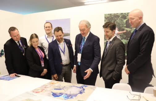 Senator Ed Markey looks at a map on a table with various Woodwell Climate staff