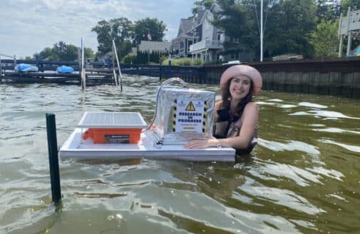 jillian greene stands in the water with her chamber based on zoe dietrich's designs