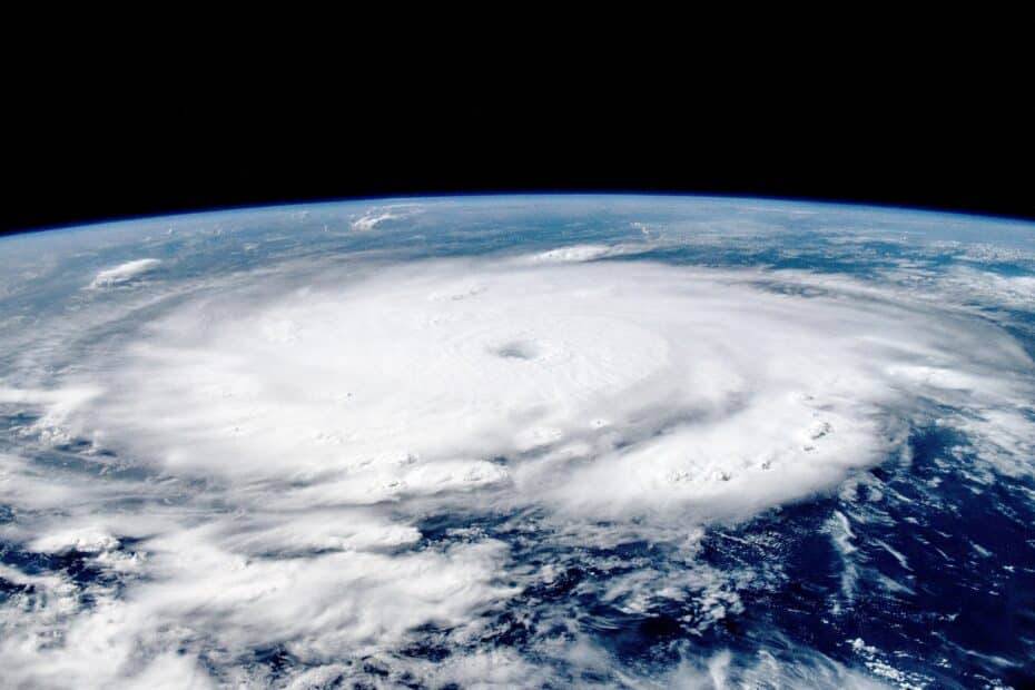 a satellite image shows the large, swirling white clouds of Hurricane Beryl in the atmosphere, with the curve of the earth visible