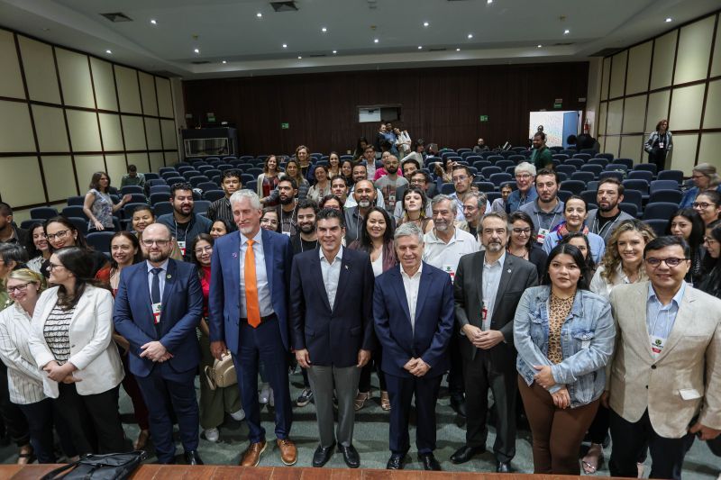 a group photo of symposium attendees in an auditorium