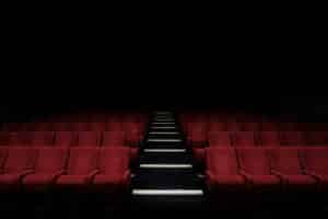 rows of red movie theater seats fade into the darkness