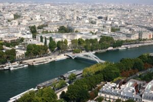 the Seine river with a white bridge, cutting through a city of light-colored buildings