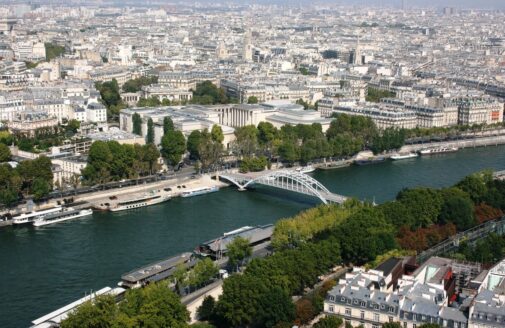 the Seine river with a white bridge, cutting through a city of light-colored buildings