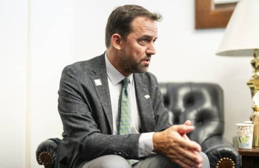 Dr. Christopher Schwalm speaking to someone off-camera, wearing a suit and tie with a Woodwell Climate lapel pin