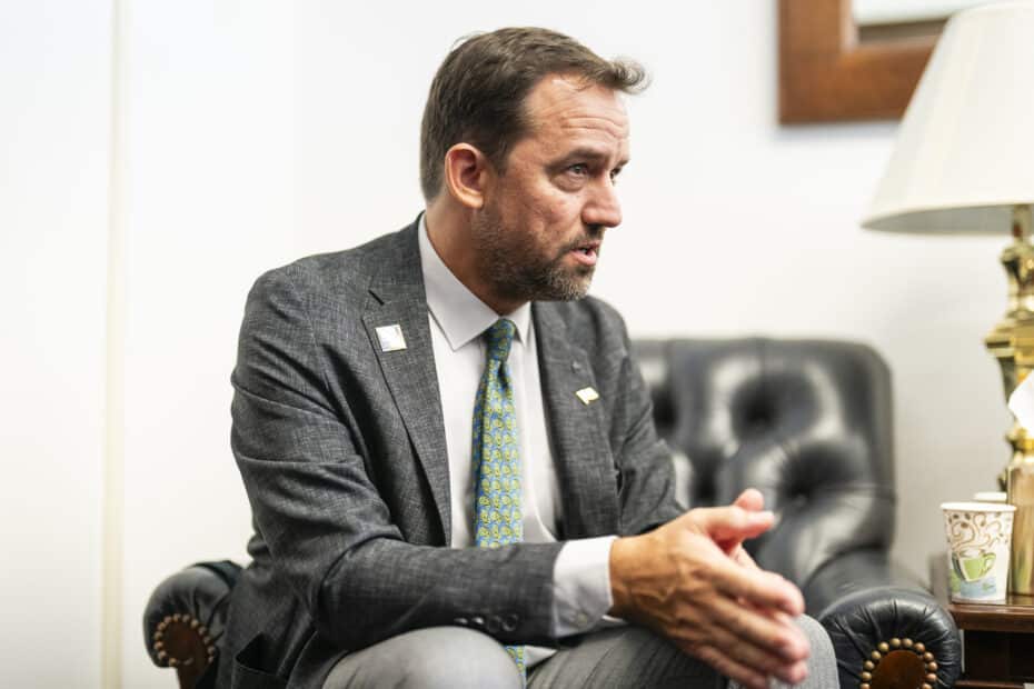 Dr. Christopher Schwalm speaking to someone off-camera, wearing a suit and tie with a Woodwell Climate lapel pin