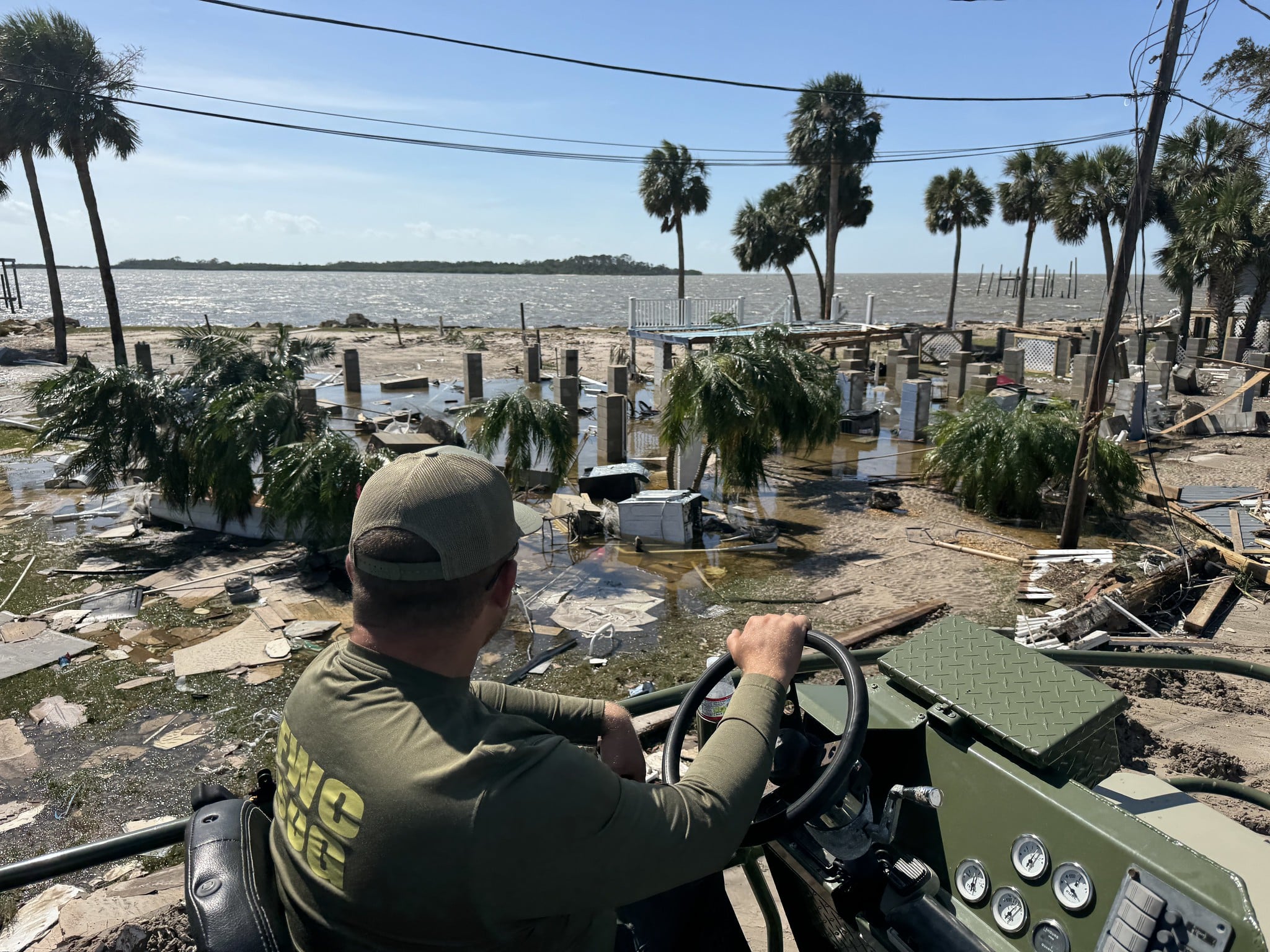 A florida fish and wildlife officer surveys damage from Hurricane helene