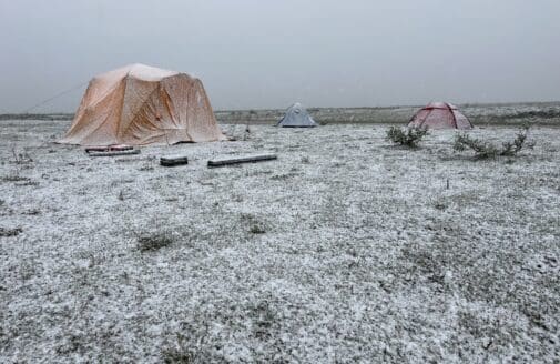 snowy tundra with yellow tent