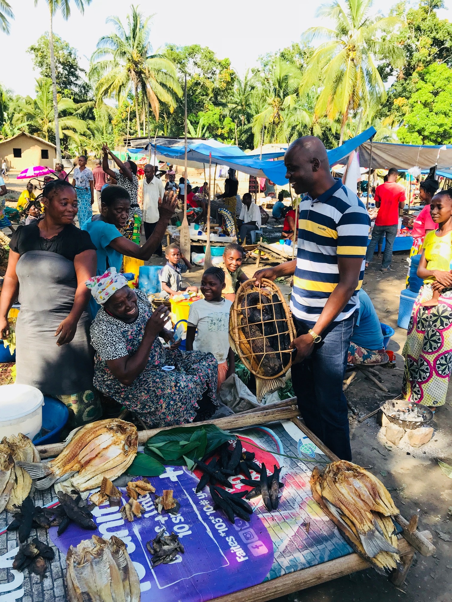 joseph zambo speaks with sellers at a local market